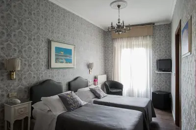 a hotel room with two beds and a window at Hotel Residenza In Farnese in Rome