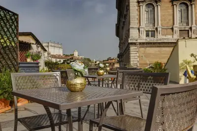 a table and chairs with a vase on a balcony at Hotel Residenza In Farnese in Rome