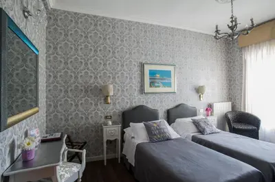 a bedroom with two beds and a table and a window at Hotel Residenza In Farnese in Rome