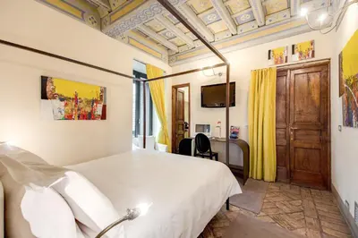 a bedroom with a white bed and a tv at Residenza Torre Colonna in Rome