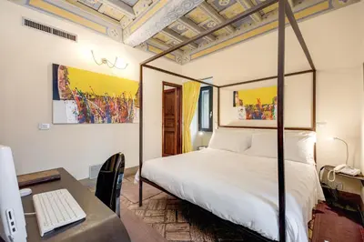 a bedroom with a bed and a desk with a computer at Residenza Torre Colonna in Rome