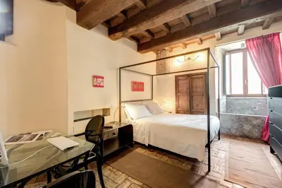 a bedroom with a bed and a desk and a mirror at Residenza Torre Colonna in Rome