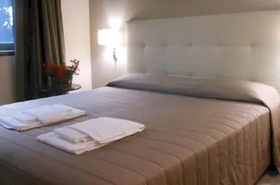 a bedroom with a bed with two towels on it at Hotel Desiderio in Rome