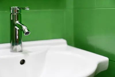 a sink in a green bathroom with a faucet at Merulana Star in Rome