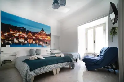 a bedroom with a large bed and a blue chair at Merulana Star in Rome