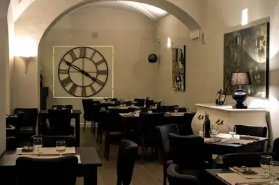 a restaurant with tables and a large clock on the wall at Target Inn Rooms in Rome