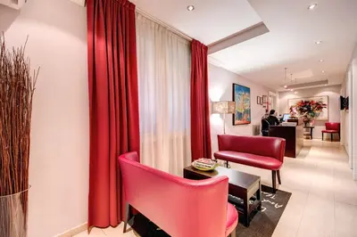 a living room with red chairs and a couch at Target Inn Rooms in Rome