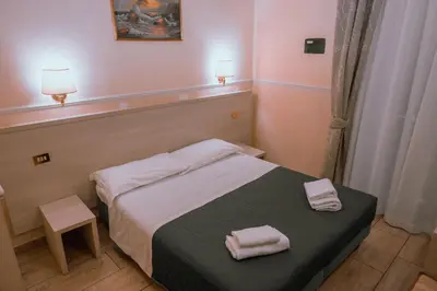 a bedroom with a bed with two towels on it at Hotel Aristotele in Rome