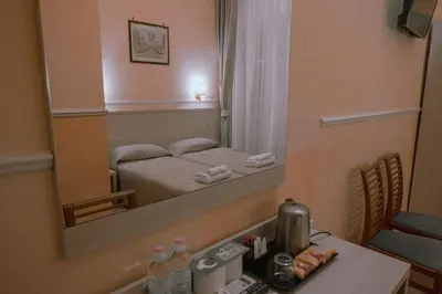 a bedroom with a bed and a large mirror at Hotel Aristotele in Rome