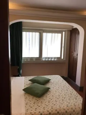 a bedroom with a bed with two green pillows on it at Hotel OKAPI in Rome