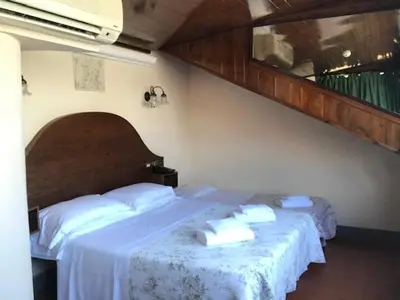 a bedroom with two beds with white sheets at Hotel OKAPI in Rome