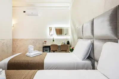 a hotel room with two beds and a table at Cola Di Rienzo Suite Guest House in Rome