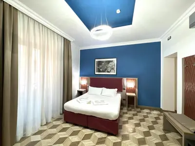 a bedroom with a bed and a blue wall at The Five Oscars Inn in Rome