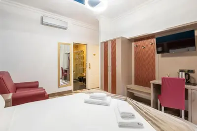 a room with a bed and a red chair at The Five Oscars Inn in Rome