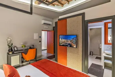 a bedroom with a bed and a tv on a wall at Via Veneto Prestige Rooms in Rome