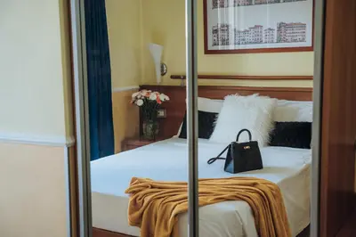 a bedroom with a bed with a black bag on it at Hotel Windrose in Rome