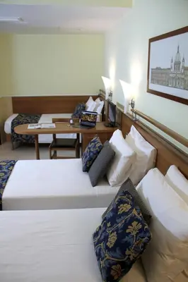 a hotel room with two beds and a desk at Hotel Windrose in Rome