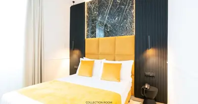 a bedroom with a king sized bed with yellow pillows at Hotel Windrose in Rome