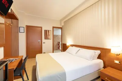 a hotel room with a bed and a desk and a desk at AlbaDomus Affittacamere o GuestHouse in Rome