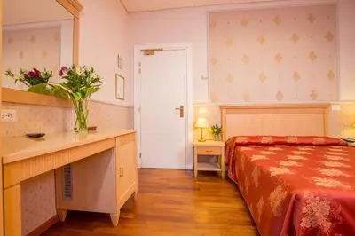 a bedroom with a bed and a table and a mirror at Hotel Arco Di Travertino in Rome