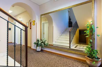 a hallway with a mirror and stairs in a building at Hotel Arco Di Travertino in Rome