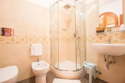 a bathroom with a shower and a toilet and a sink at Hotel Arco Di Travertino in Rome