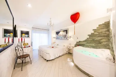 a bedroom with a tub and a bed with a heart on the wall at Suites Roma Tiburtina Elegance in Rome