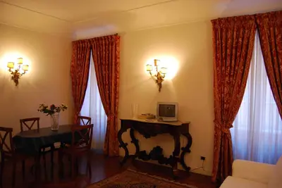 a living room with a table and two windows at Giulio Caesar in Rome