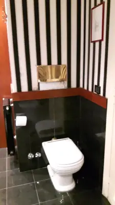 a black and white bathroom with a toilet and a chair at Giulio Caesar in Rome