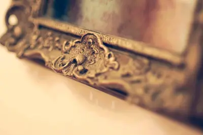 a close up of a gold picture in a mirror at Central Domus Roma in Rome