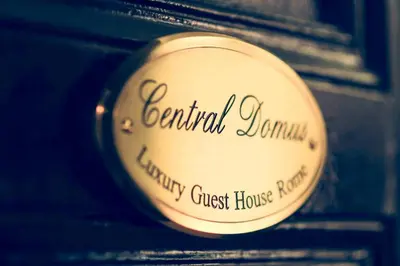 a sign for a bennell jamil charity guest house paper at Central Domus Roma in Rome