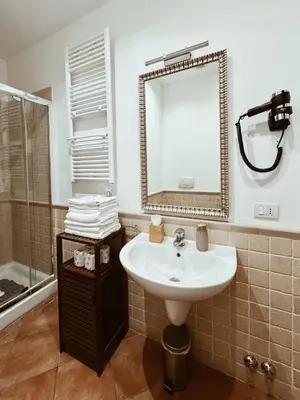 a bathroom with a sink and a mirror and a shower at Residenza Sciarra Suites in Rome