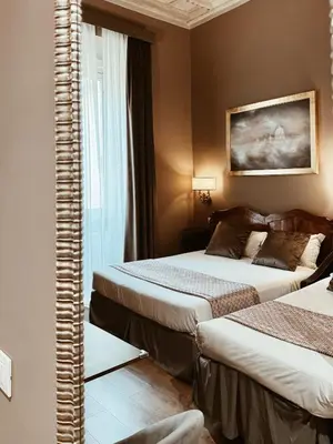a hotel room with two beds and a mirror at Residenza Sciarra Suites in Rome
