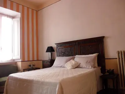 a bedroom with a bed with white sheets and a window at Suite 59 romeholidayhome in Rome
