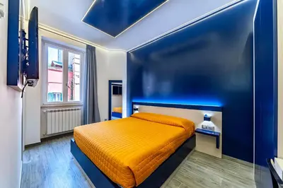 a bedroom with an orange bed in a blue room at Guesthouse Pop in Rome