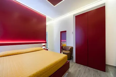 a bedroom with a bed and a red wall at Guesthouse Pop in Rome