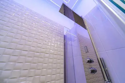 a bathroom with white tiled walls and a purple door at Guesthouse Pop in Rome