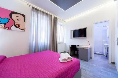 a bedroom with a pink bed and a desk at Guesthouse Pop in Rome