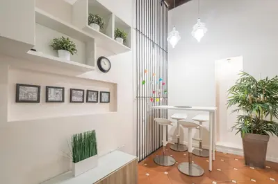 a room with white walls and a counter with stools at Margana Suite in Rome