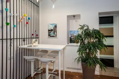 a room with a white table and stools and a plant at Margana Suite in Rome