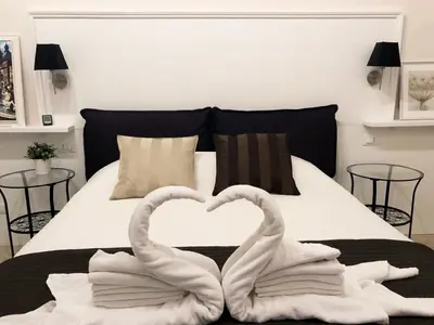 two swans making a heart shape on a bed at Margana Suite in Rome