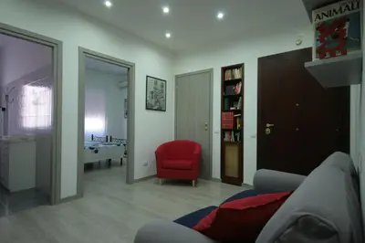 a living room with a red chair and a bedroom at Casa di Angela in Rome