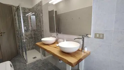 a bathroom with two white sinks on a wooden counter at Casa di Angela in Rome