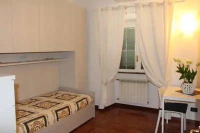 a bedroom with a bed and a table and a window at Le Bellezze Vaticane in Rome