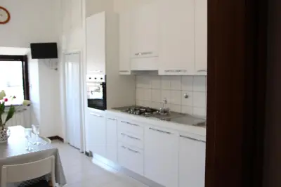 a white kitchen with white cabinets and a table at Le Bellezze Vaticane in Rome