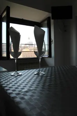 two wine glasses sitting on a table in front of a window at Le Bellezze Vaticane in Rome
