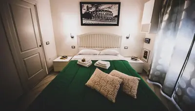 a small bedroom with a green bed with two towels at B&B Saint Paul in Rome