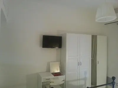 a room with a white cabinet and a tv on the wall at B&B Saint Paul in Rome