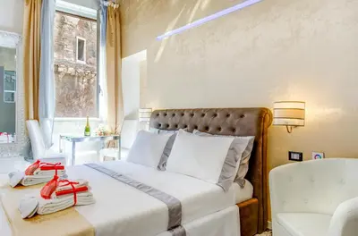 a bedroom with a bed and a chair and a window at Hub Pantheon in Rome