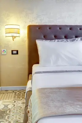 a bedroom with a bed with a headboard and a lamp at Hub Pantheon in Rome